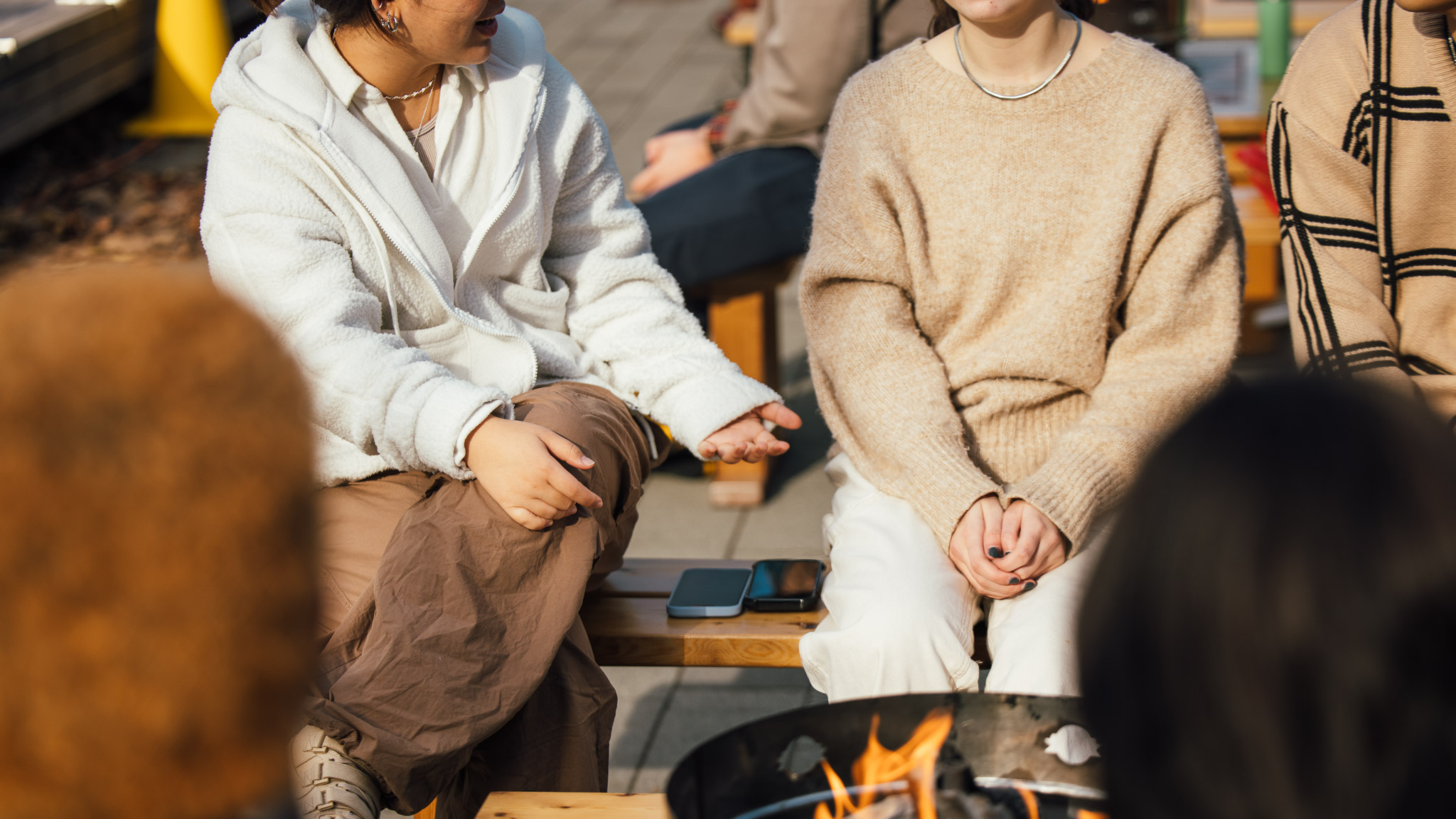 Students talking in front of a fire pit
